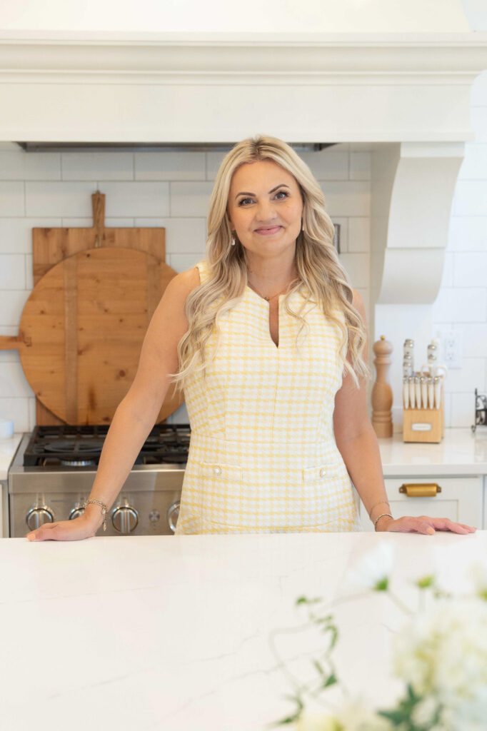 Small business owner standing at the kitchen counter smiling at the camera during a brand photoshoot.Following a brand photoshoot checklist can help you choose the perfect outfit,