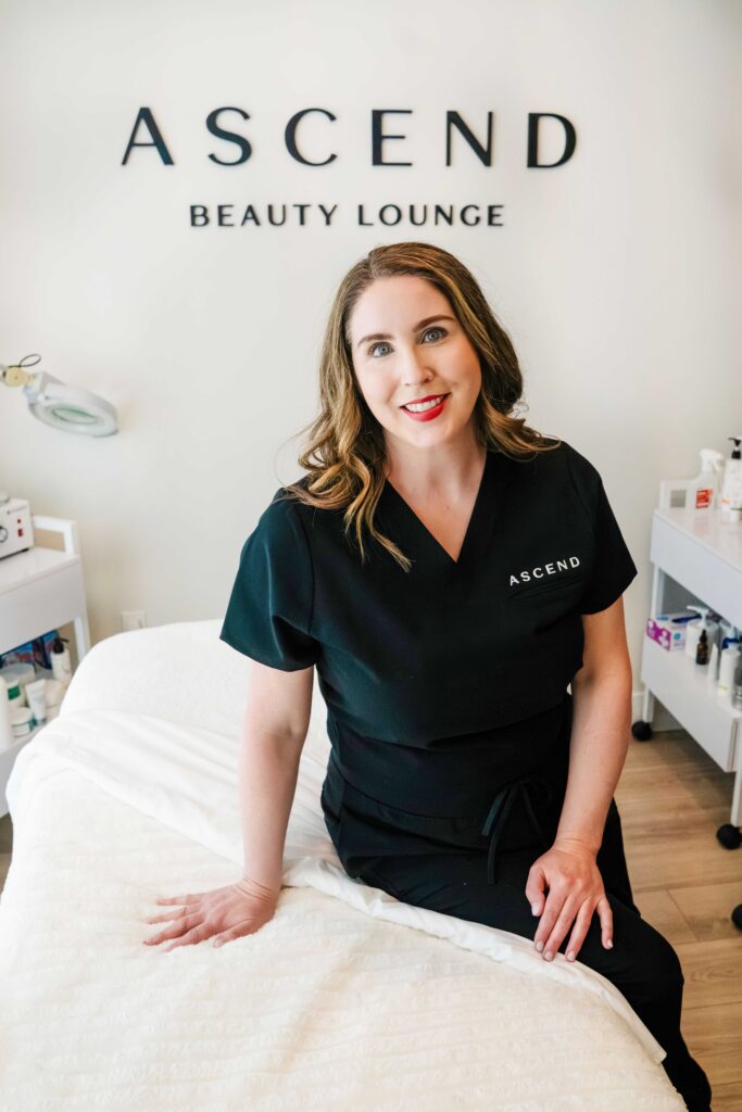 Branding photo of an esthetician sitting on the edge of a treatment table.