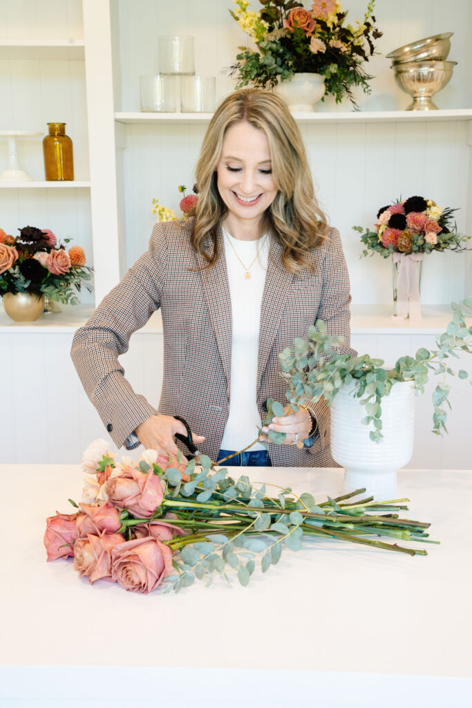 Image of a florist cutting the end off of roses during a brand photography session in Portland, OR