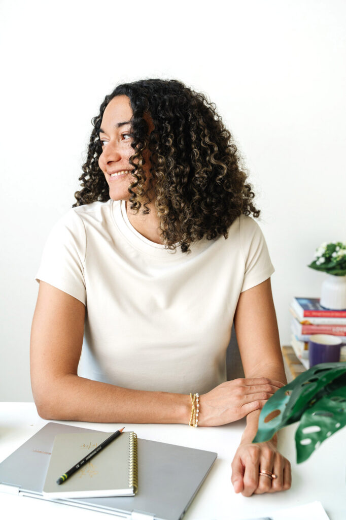 A mental health therapist sitting at her desk smiling and looking off to the side