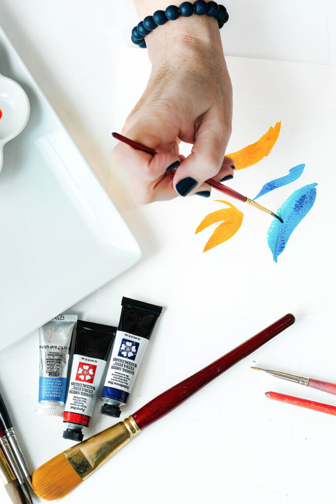 Close up photo of an artist's hand watercoloring. 