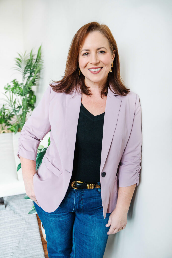 Women business owner posing during her branding session by leaning against a wall.