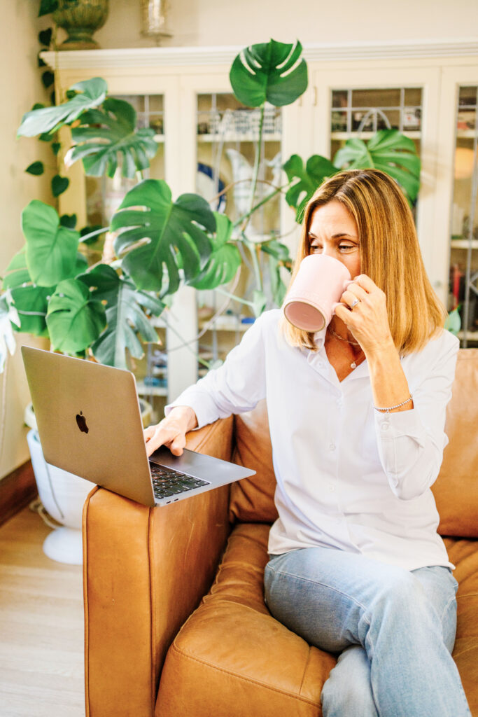 Nutritionist sipping coffee and looking at her laptop